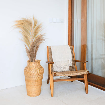 Vase KIDUNG en rotin avec herbes de la pampa posé au sol dans une chambre blanche