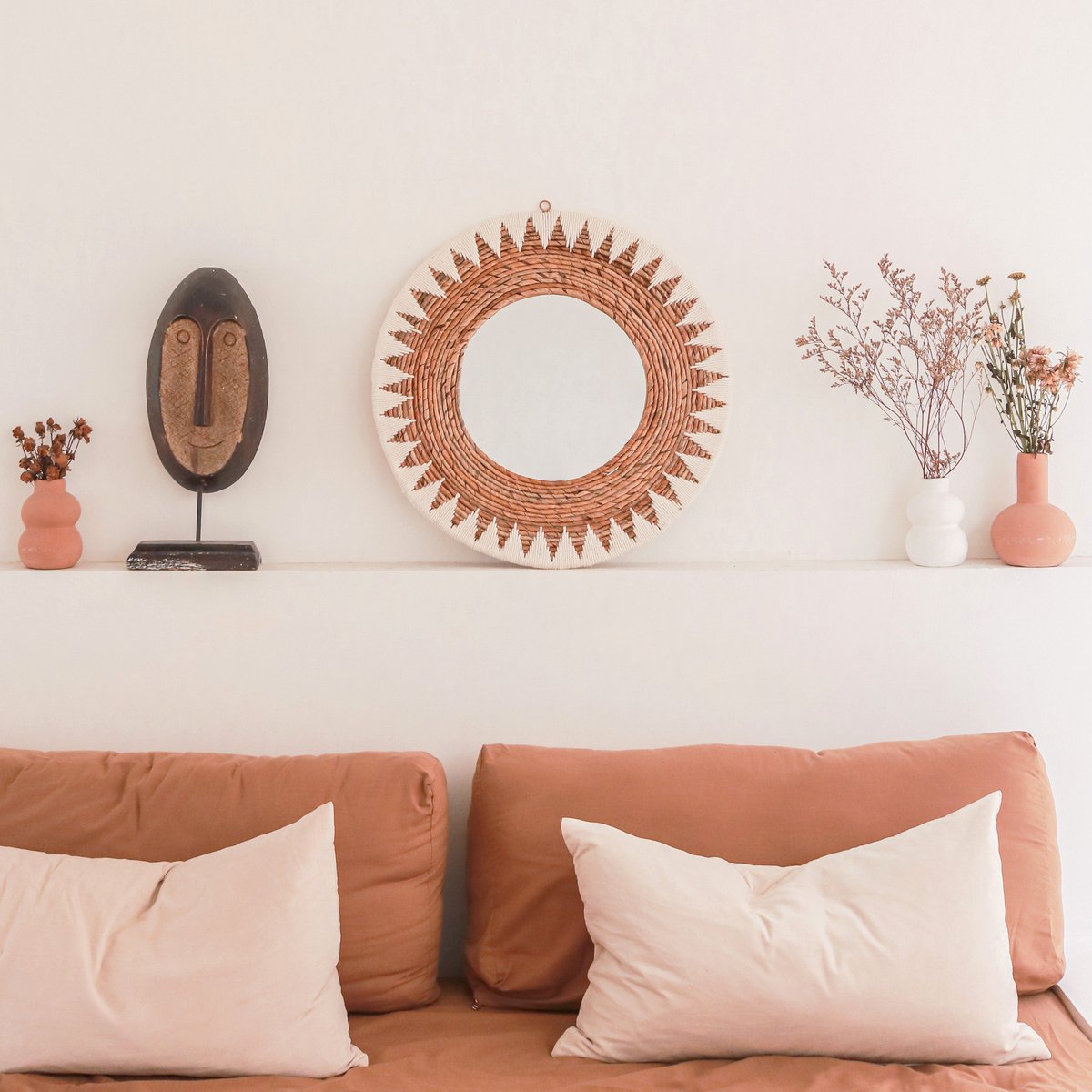 Miroir AWAN au-dessus d'un canapé terracotta avec vases décoratifs dans un salon bohème
