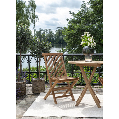Chaise Toledo en teck massif sur terrasse méditerranéenne avec table ronde et olivier
